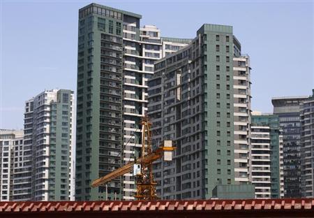 A crane is seen at a construction site in front of a residential complex in Beijing